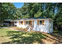 White brick ranch house with wood accents and a well-manicured lawn at 207 Okemah Se Trl, Marietta, GA 30060