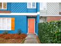 Renovated townhome boasts a bright coral door and lush green hedge at 2106 Childress Sw Dr, Atlanta, GA 30311