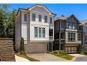 Three story home with light-grey siding, two car garage, and a balcony at 770 Grove Bnd, Decatur, GA 30030