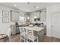 Modern kitchen with gray cabinets, granite counters, and stainless steel appliances at 527 Lanier Way, Temple, GA 30179