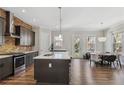 Kitchen and dining area features stainless appliances, granite countertops, island with seating, and natural light at 2357 Rover Ct, Atlanta, GA 30317