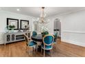 Formal dining room with round table, teal chairs, and hardwood floors at 500 Westover Nw Dr, Atlanta, GA 30305