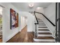 Bright entryway with hardwood floors, elegant staircase, and large art piece at 500 Westover Nw Dr, Atlanta, GA 30305