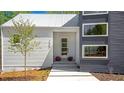 Charming home entrance with a modern glass door, stone walkway, manicured landscaping, and visible house number at 160 Cedarwood Ln, Roswell, GA 30075
