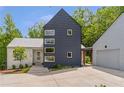 Modern home featuring unique architectural design, with a two-car garage, and surrounded by mature trees at 160 Cedarwood Ln, Roswell, GA 30075