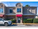 Townhouse with red awning, landscaping, and car parked in front at 3301 Henderson Mill Rd, Atlanta, GA 30341