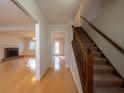Inviting entryway featuring hardwood floors, staircase, and views into the spacious living area with a cozy fireplace at 3640 Longfellow Trl, Marietta, GA 30062