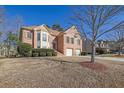 Brick two-story house with attached two-car garage and landscaped yard at 3643 Southland Ne Dr, Buford, GA 30519