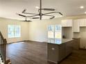 Bright living room features wood floors and a modern light fixture over the kitchen island at 195 Ridgecrest Way, Stockbridge, GA 30281