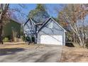 Attractive blue home with a two-car garage, neat landscaping, and a well-maintained front lawn at 1878 Hamby Place Nw Dr, Acworth, GA 30102