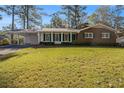 Charming brick ranch home with a manicured lawn and mature trees at 2540 Thornton Dr, Atlanta, GA 30349