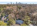 Aerial view of a home nestled in a forest with the city skyline in the distance, showing privacy and location at 4152 Club Dr, Atlanta, GA 30319