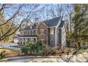Side view of a home with gray siding, stone accents, surrounded by trees, enhancing its curb appeal at 4152 Club Dr, Atlanta, GA 30319