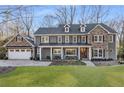 Beautiful gray two-story home with stone accents, dormer windows, a covered porch, and a spacious front yard at 4152 Club Dr, Atlanta, GA 30319