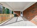 Covered back porch with wood railing and concrete flooring at 5310 Timbo Ln, Mableton, GA 30126
