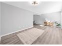 Bright, open living room with light grey walls, wood floors, a rug, and modern light fixture at 3091 Colonial Way # E4, Chamblee, GA 30341