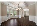 Dining room with hardwood floors, tray ceiling, and wainscoting at 6235 Stillwood Ln, Cumming, GA 30041