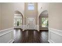 Two-story foyer with dark hardwood floors and white wainscoting at 6235 Stillwood Ln, Cumming, GA 30041