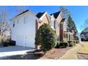 Side view of a two-story home showcasing a large white garage at 2968 Winterthur Close Nw, Kennesaw, GA 30144