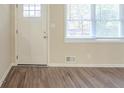 Front entry with white door, wood-look flooring, and window with blinds at 3701 Glen Mora Dr, Decatur, GA 30032