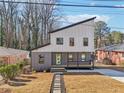 Modern two-story house with gray and white siding, a light green door, and a stone path at 665 Ferris Sw St, Atlanta, GA 30310
