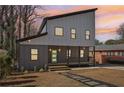 Modern two-story house with gray and white siding, a light green door, and a stone path at 665 Ferris Sw St, Atlanta, GA 30310