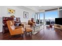 Cozy living room showcasing hardwood floors, comfortable seating, piano and expansive windows with city views at 3325 Piedmont Ne Rd # 2702, Atlanta, GA 30305