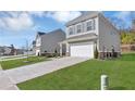 Two-story house with gray siding, landscaping, and a driveway at 9026 Jim Purcell Dr, Covington, GA 30014