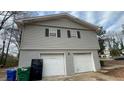 Two-car garage with white doors and gray siding at 1272 Marlwood Ct, Stone Mountain, GA 30083