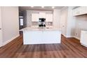 Spacious kitchen island with sink, granite countertop, and white cabinets, perfect for meal preparation at 4090 Cavalier Way, Duluth, GA 30097
