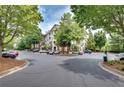 Exterior view of condo community showcasing mature trees, parking and well maintained grounds at 1965 Nocturne Dr # 1209, Alpharetta, GA 30009