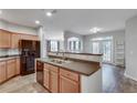 Modern kitchen with stainless steel appliances, dark countertops, and wood cabinets, and a view into the living room at 1965 Nocturne Dr # 1209, Alpharetta, GA 30009