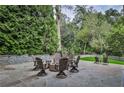 Stone backyard patio with a cozy fire pit and comfortable Adirondack seating surrounded by manicured landscaping at 1658 E Clifton Ne Rd, Atlanta, GA 30307