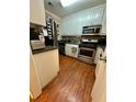 Galley kitchen with white cabinets, stainless steel appliances, and wood flooring at 710 River Run Dr, Atlanta, GA 30350