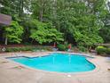Community swimming pool surrounded by lush trees and comfortable seating at 710 River Run Dr, Atlanta, GA 30350