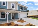 Home's entrance featuring a front porch with white pillars, a dark-colored door, and a concrete driveway at 126 Cherry Glen Way, Euharlee, GA 30145