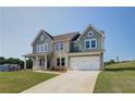 Charming two-story home features a covered front porch, a two-car garage, and a well-manicured lawn at 204 Blanton Ln, Stockbridge, GA 30281