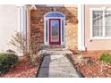 Red front door with stonework and a walkway at 4140 Cherry Ridge Walk, Suwanee, GA 30024