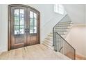 Elegant entryway with arched double doors, hardwood floors, and a grand staircase at 590 Clubwood Ct, Marietta, GA 30068