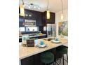 Contemporary kitchen island with breakfast bar, granite countertops, stainless steel fridge, and pendant lighting at 972 Dekalb Ne Ave # 203, Atlanta, GA 30307