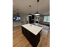 Kitchen island with white quartz countertop and dark cabinetry at 1217 Eagles Nest Cir, Carrollton, GA 30116