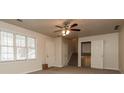 Bright and airy living room with large windows, carpet floors, and a ceiling fan at 2808 Mountbery Dr, Snellville, GA 30039