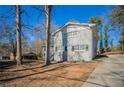 Gray two-story house with a driveway and mature trees at 2668 Woodfen Dr, Ellenwood, GA 30294