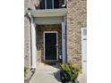 Black front door entry with brick exterior and landscaping at 449 Broder Farms Dr, Stockbridge, GA 30281