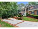 Two-story brick home with a large driveway and landscaping at 1120 Heards Ferry Rd, Sandy Springs, GA 30328