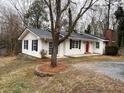 Lovely home showcasing a metal roof, brick chimney and white siding accented by black shutters and a pop of color on the front door at 240 Dogwood Dr, Canton, GA 30114