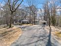 Wide driveway leading to a ranch-style home with a two-car garage in a wooded setting at 414 Dogwood Dr, Canton, GA 30114