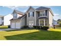 Two-story house with a two-car garage and a landscaped front yard at 4450 Millenium View Ct, Snellville, GA 30039