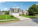 Well-maintained two-story home with a lush green lawn, two-car garage, and mature trees at 4450 Millenium View Ct, Snellville, GA 30039