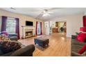 Open living room featuring a fireplace, hardwood floors, and an adjacent kitchen area at 4450 Millenium View Ct, Snellville, GA 30039
